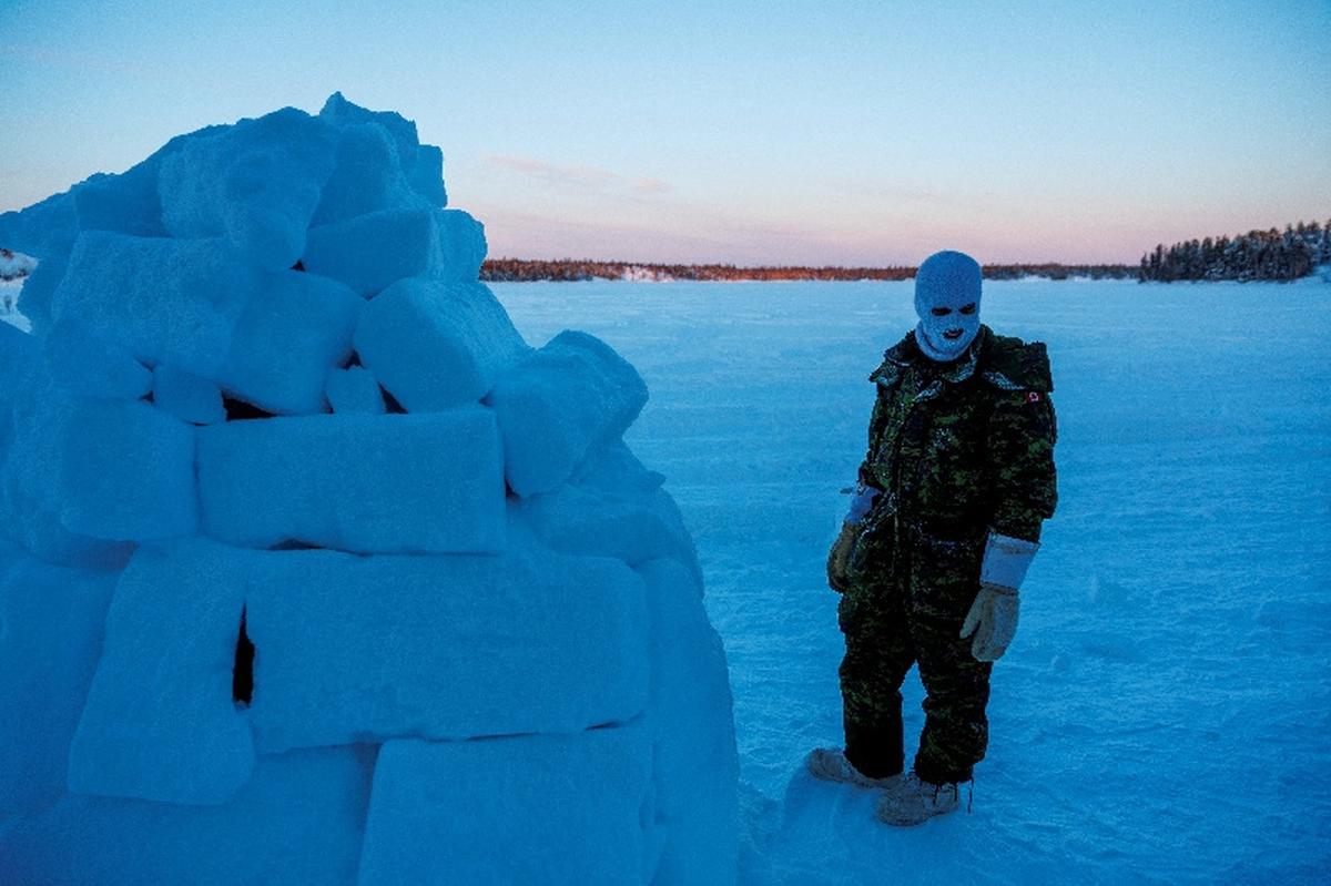 FILE PHOTO: A member of 41 Canadian Brigade Group, as part of Task Force Grizzly, pauses while building an igloo as Canadian Armed Forces deploy to "Operation Nanook-Nunalivut," a yearly series of drills designed to highlight the military's ability to defend the Canadian Arctic, in Yellowknife, Northwest Territories, Canada, February 16, 2026. REUTERS/Carlos Osorio/File Photo/File Photo