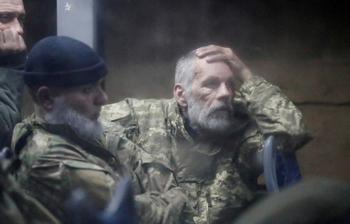 FILE PHOTO: Service members of the Ukrainian armed forces, who surrendered at the besieged Azovstal steel mill in Mariupol in the course of Ukraine-Russia conflict, sit in a bus upon their arrival under the escort of the pro-Russian military in the settlement of Olenivka in the Donetsk region, Ukraine, May 20, 2022.        REUTERS/Alexander Ermochenko/File Photo