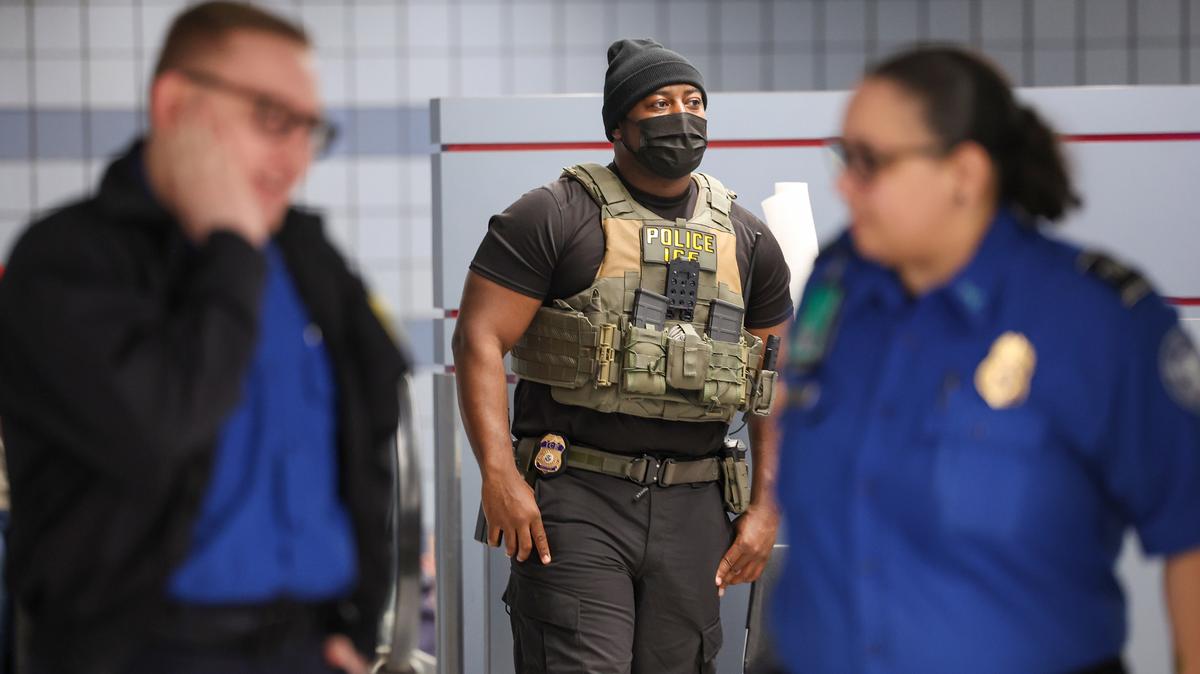 A masked Immigration and Customs Enforcement agent stands just inside a passenger exit area in Terminal 1 at O’Hare International Airport on March 23, 2026. (Stacey Wescott/Chicago Tribune/TNS)