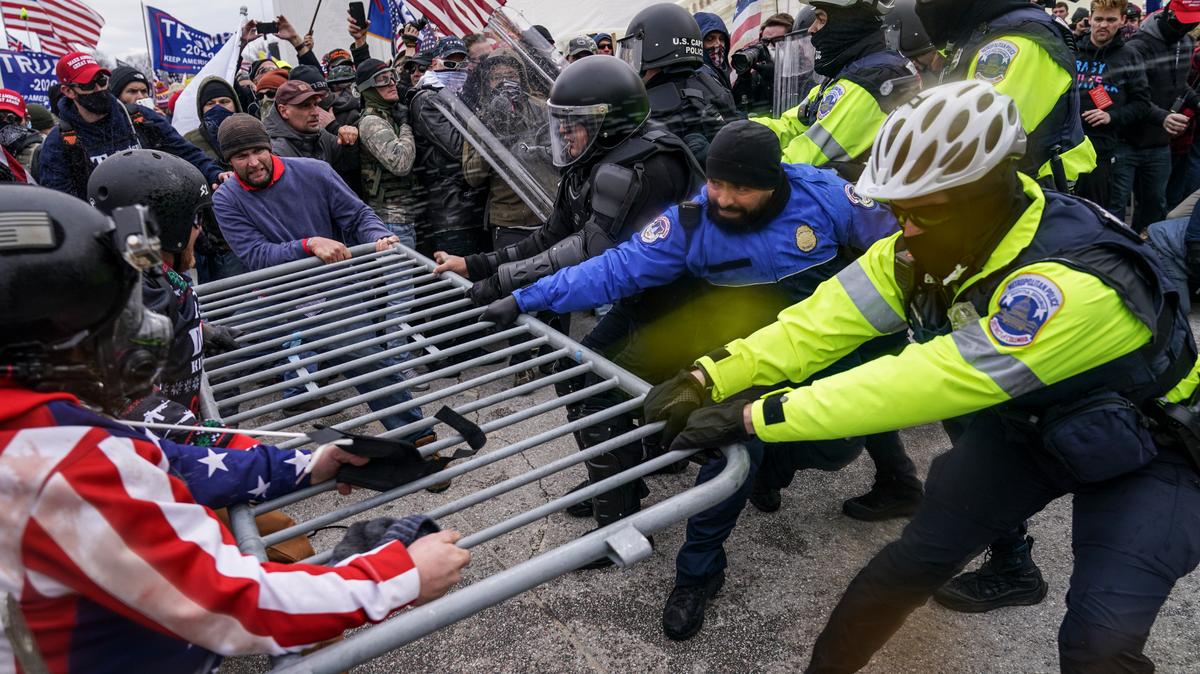 Simpatizantes de Trump tratan de pasar a través de una barrera de la policía, el miércoles 6 de enero de 2021, en el Capitolio, en Washington. (AP Foto/John Minchillo)