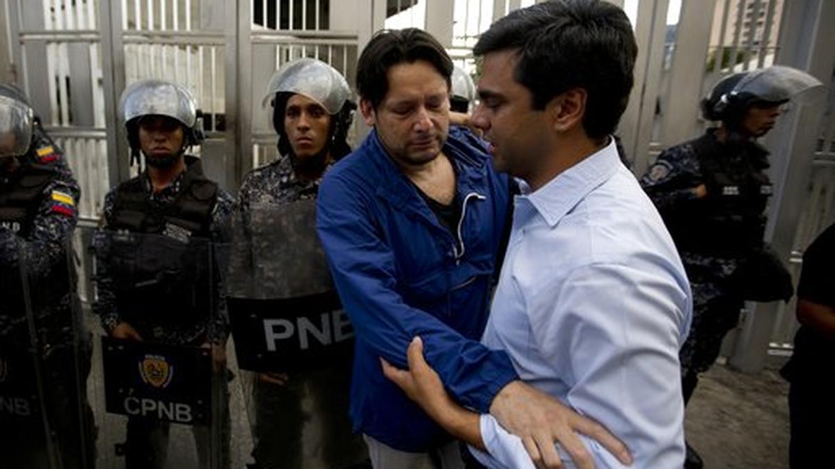 Members of the First Justice party, or Primero Justicia, hug outside the Bolivarian National Security Service headquarters in Caracas on Monday, Oct. 8. Venezuela’s attorney general said Monday that jailed councilman Fernando Alban, arrested on suspicion of involvement in an assassination attempt on President Nicolas Maduro, killed himself by jumping out of a 10th floor window.