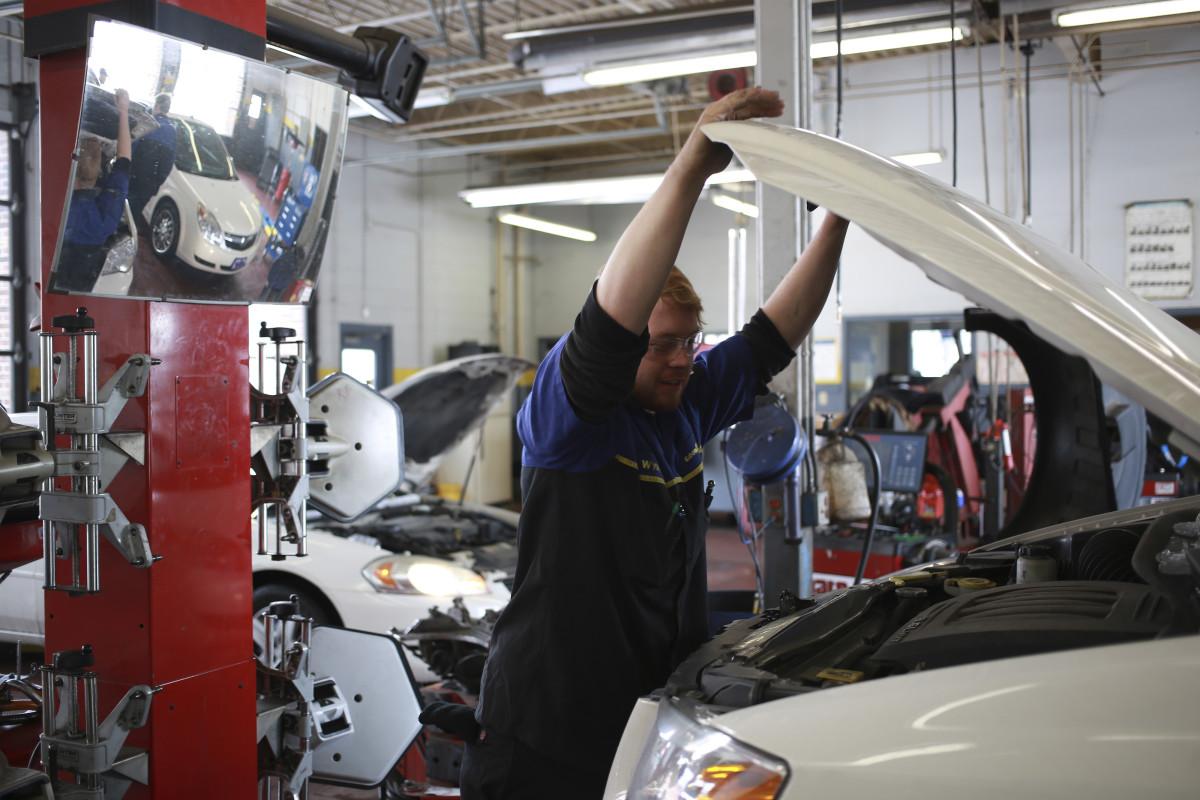 A service technician works under the hood of a customer’s vehicle at a Goodyear Tire and Rubber Co. Auto Service Center in Millington, Tennessee