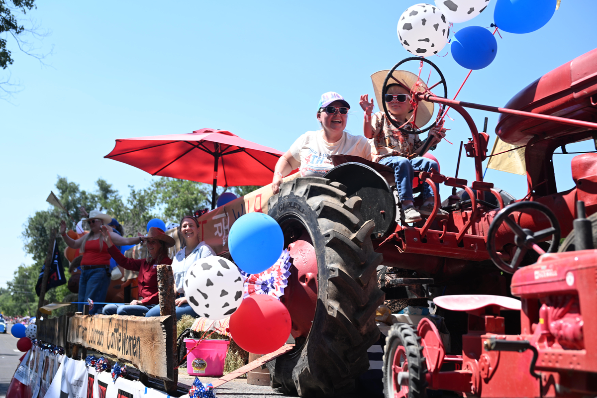 A boy riding a tractor waves during the Greeley Stampede's Independence Day parade in Greeley, Colo., July 4, 2026. America celebrates the 250th anniversary of its independence today, with people from one end of the country to the other marking the milestone with fireworks, parades and concerts. (Mark Makela/The New York Times)