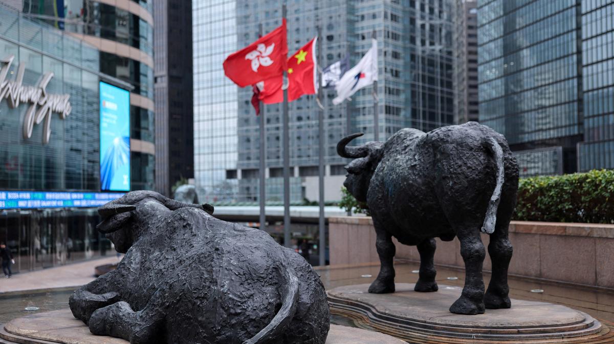 FILE PHOTO: Bull statues near screens showing the Hang Seng stock index and stock prices outside Exchange Square, in Hong Kong, China, February 3, 2026. REUTERS/Tyrone Siu/File Photo