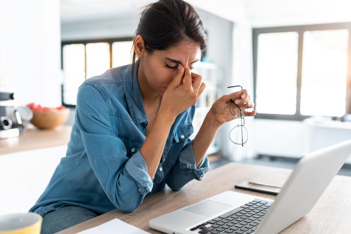  Stock image: A stressed woman sitting in front of a laptop. 