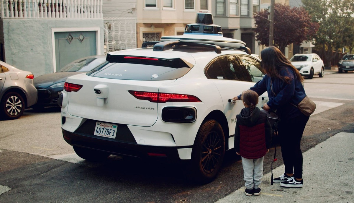  Passengers shown entering a Waymo Jaguar I-Pace