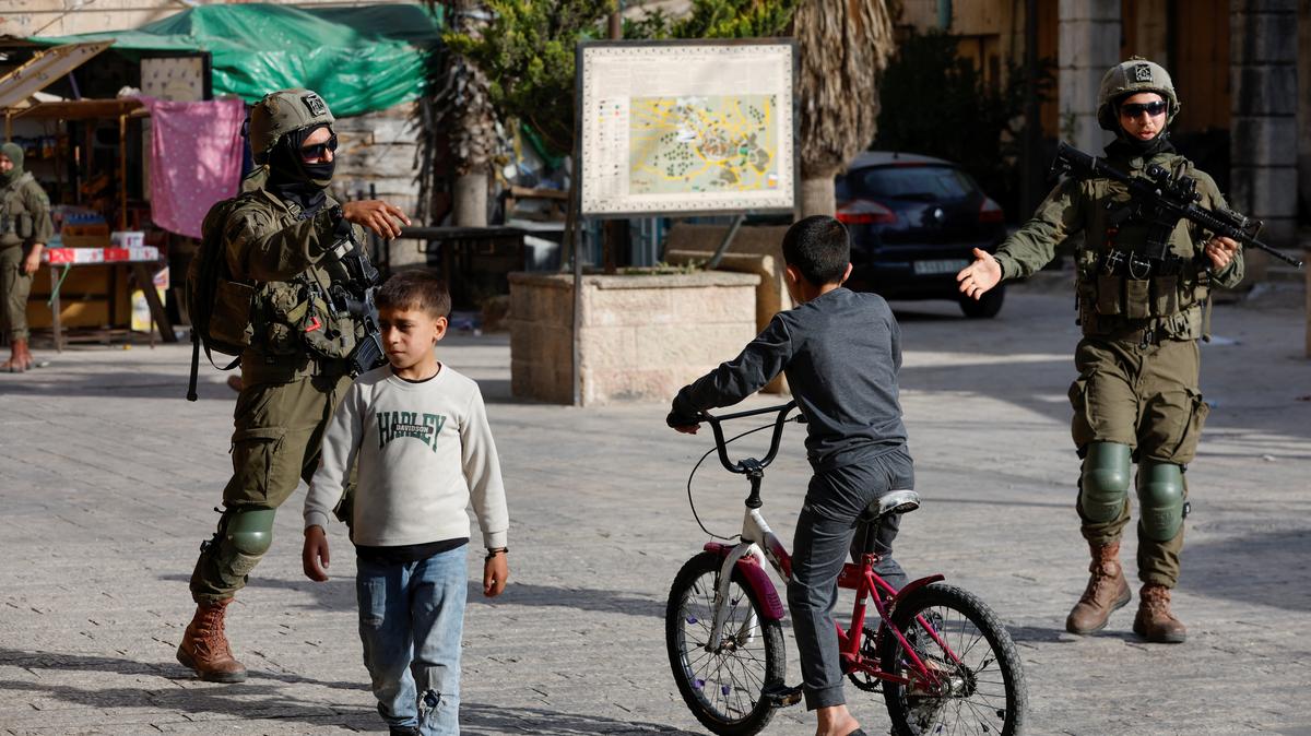 Israeli soldiers direct Palestinian children to disperse during a weekly settlers' tour in Hebron, in the Israeli-occupied West Bank, May 9, 2026. REUTERS/Mussa Qawasma