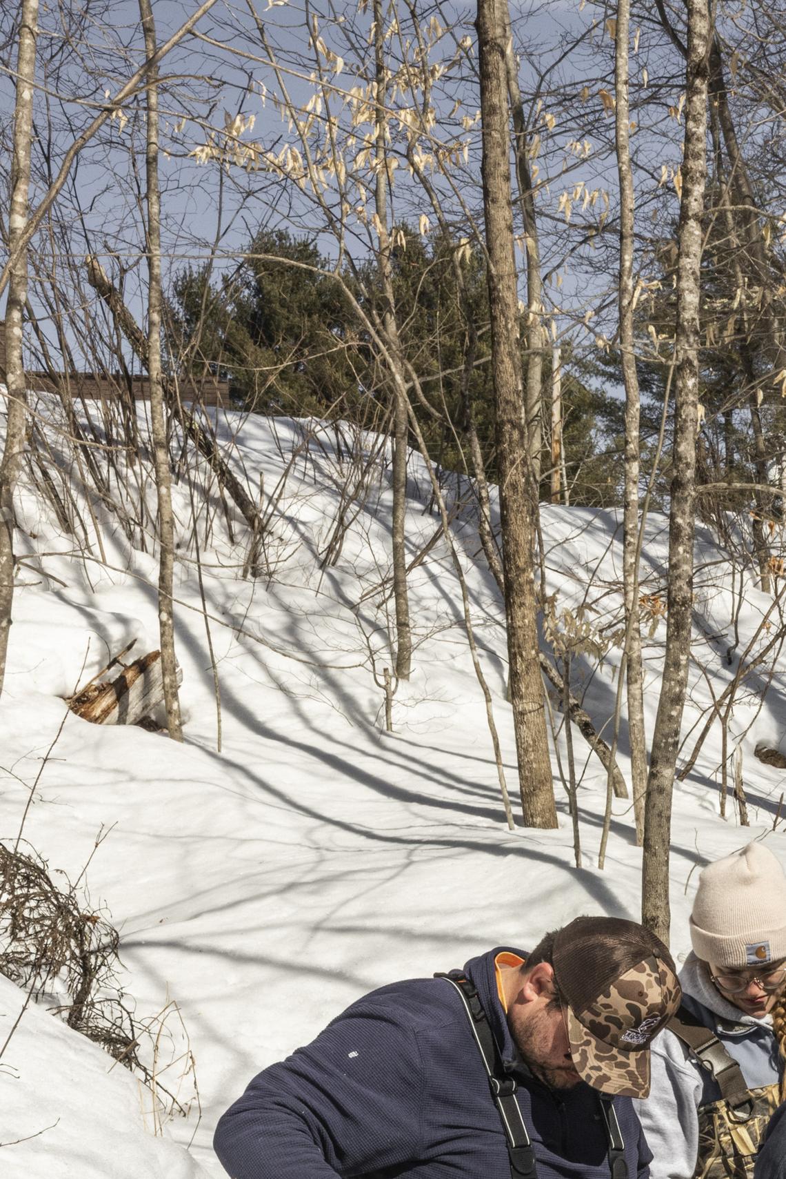 A team uses a makeshift system with a water pump to insert salmon eggs into the gravel bed of a brook, in Farmington, Maine, March 3, 2026. The fragile hope for salmon recovery in Maine: a long-term project to remove or modify dams may clear the way for endangered wild Atlantic salmon to swim freely up to the Sandy River, but it faces opposition from business and lawmakers. (Greta Rybus/The New York Times)