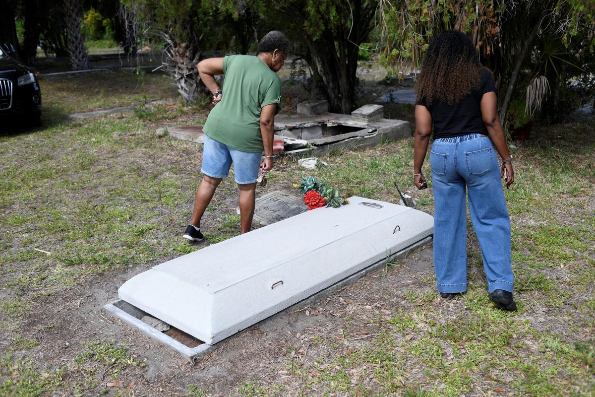 Edrena Love Freeman and her daughter Nicole Smith look for family members' graves at the Old Memphis Cemetery, a predominantly African-American cemetery in Palmetto, to inspect the graves of their loved ones along with others, after 17 gravesites were vandalized, in Palmetto, Florida, U.S. May 14, 2026. Authorities say “Trump” and “DeSantis” were spray-painted in red across multiple tombs as police continue investigating the incident. REUTERS/Octavio Jones