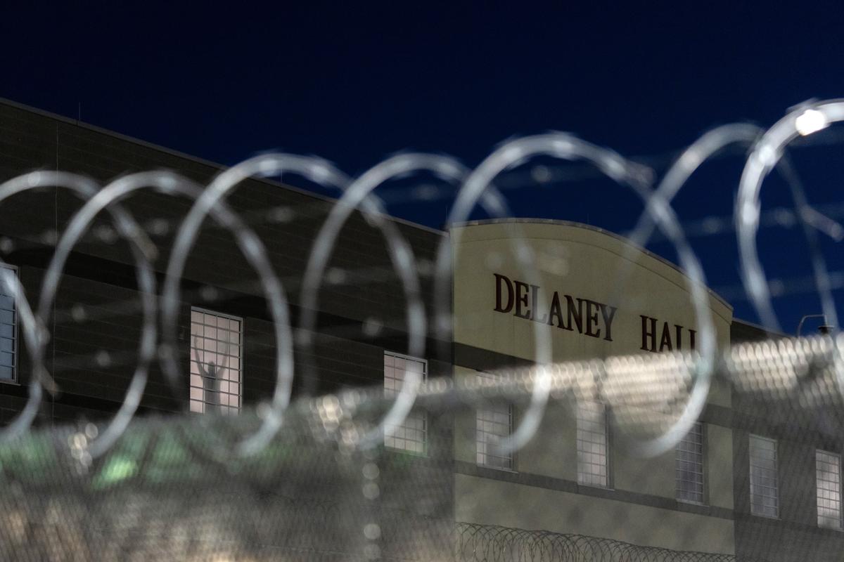 An inmate stands at a window at Delaney Hall, an immigration detention center in Newark, N.J., as demonstrators gather outside on Thursday night, May 28, 2026. For nearly a week, relatives of migrants at Delaney Hall have said that some detainees have been on a hunger strike at the facility. Federal officials have denied that a hunger strike is taking place. (Todd Heisler/The New York Times)