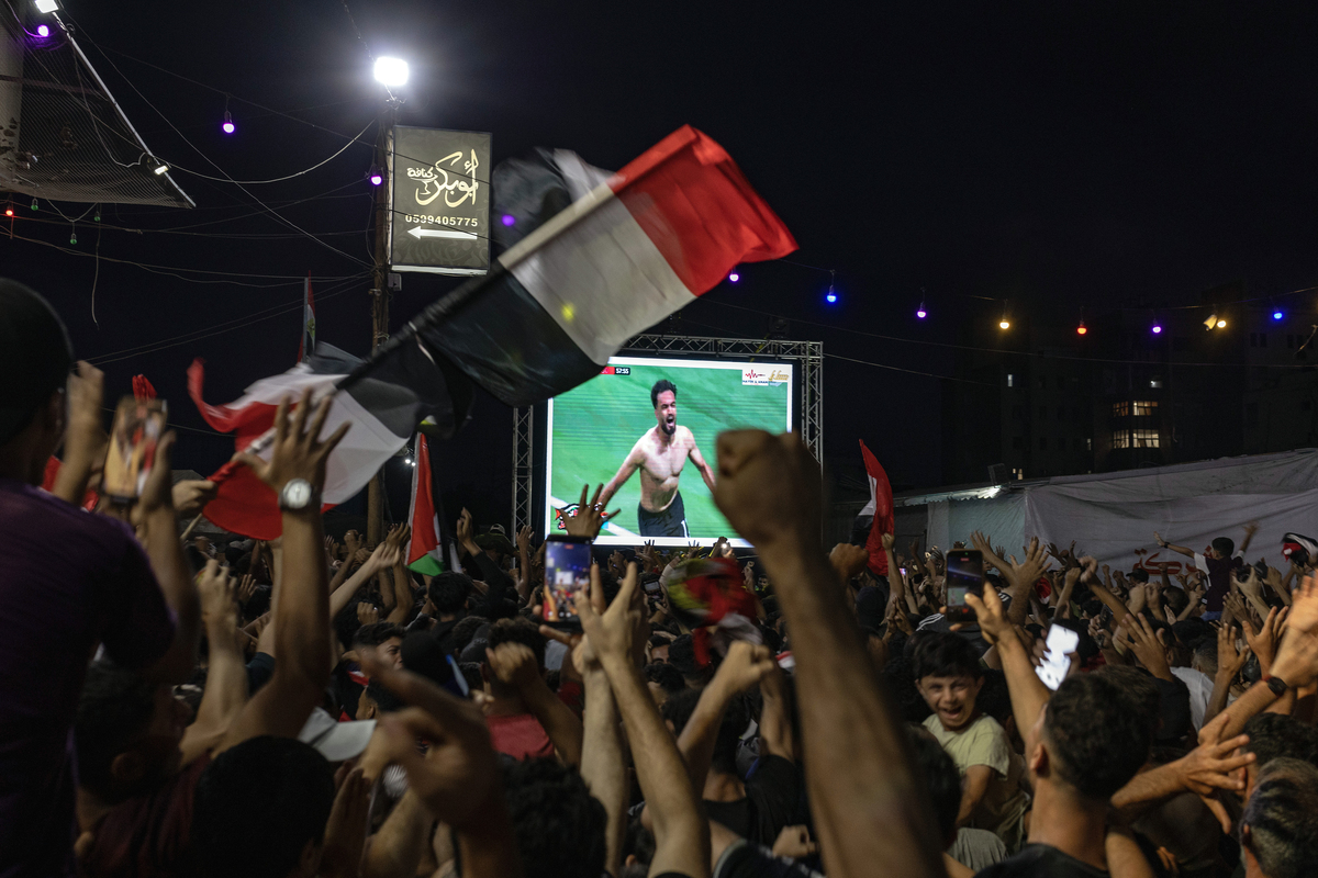 People in Gaza City cheer and wave the flag of Egypt as they watch that country's team take on Argentina in Round 16 of the World Cup on Tuesday night, July 7, 2026. After watching Egypt lead for almost the entire match, a last-minute victory by Argentina has driven fans to tears and conspiracy theories. (Saher Alghorra/The New York Times)