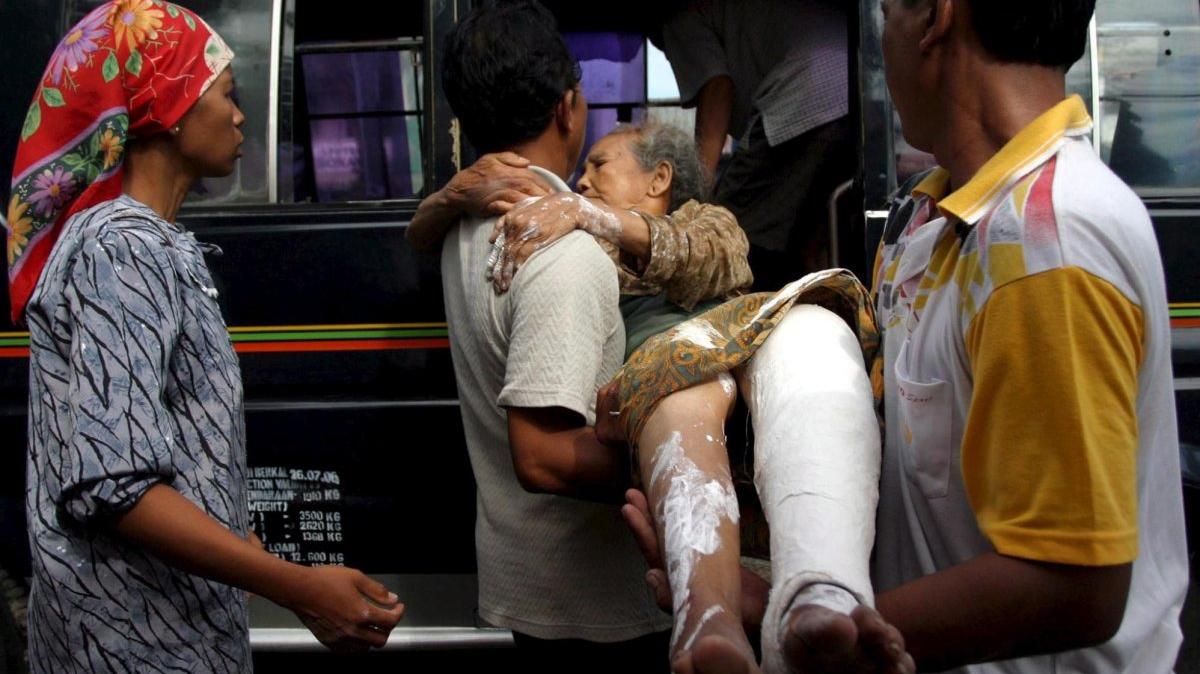 Men carry an injured woman to a bus after an earthquake rocked in Klaten, Central Java, Indonesia, on May 27, 2006. File Photo by Himawan/EPA