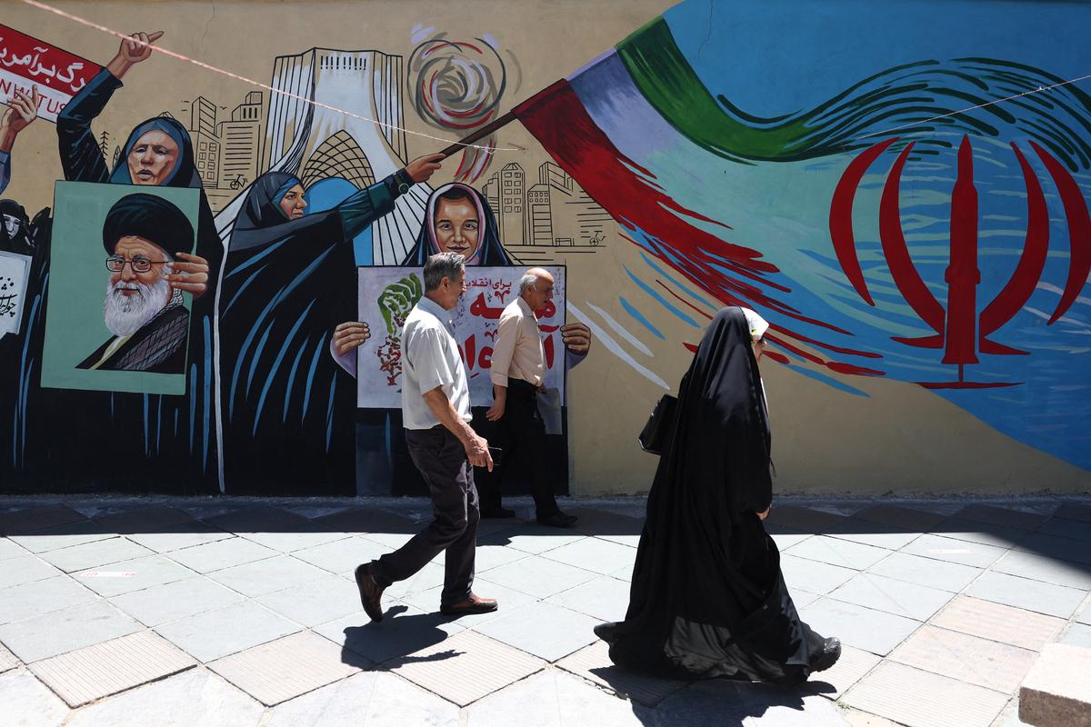 People walk on a street near a mural featuring an image of the late Supreme Leader of Iran, Ayatollah Ali Khamenei, in Tehran, Iran, June 1, 2026. Majid Asgaripour/WANA (West Asia News Agency) via REUTERS