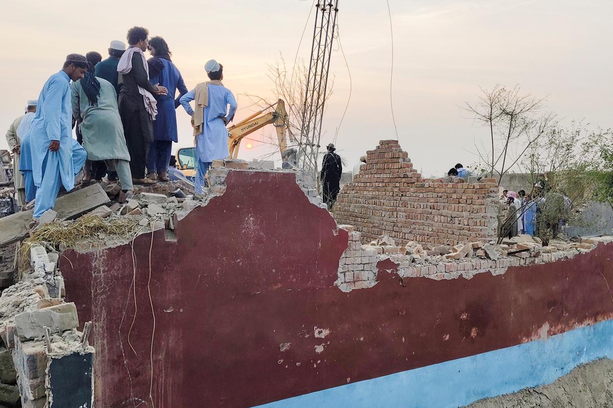Residents gather on the rubble of a damaged police post after a car bombing in Bannu, Khyber Pakhtunkhwa province, Pakistan May 10, 2026. Picture taken with a mobile phone. REUTERS/Ehsan Khattak