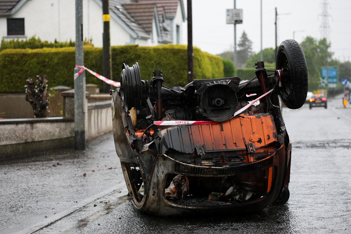 A burnt car lies at Antrim Road, in the aftermath of anti-immigrant protests following a knife attack on June 8, which left a man seriously injured and prompted police to declare a critical incident, in Belfast, Northern Ireland, June 11, 2026. REUTERS/Isabel Infantes