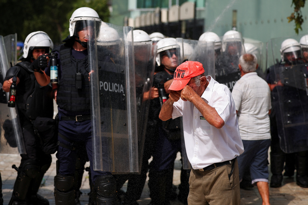 A man reacts, as police officers equipped with riot shields deploy pepper spray, during a demonstration against the government, following weeks of protests against a planned luxury resort backed by a company linked to Jared Kushner, the son-in-law of U.S. President Donald Trump, on an environmentally sensitive part of the Adriatic coast, in Tirana, Albania, July 2, 2026. REUTERS/Florion Goga