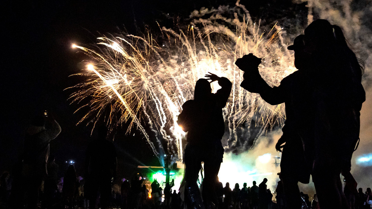 Festival goers watch a firework display.