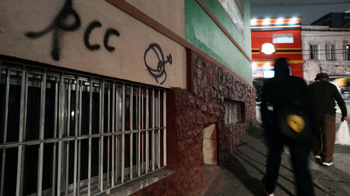 FILE PHOTO: People walk past a sign reading "PCC", referring to Brazilian drug gang Primeiro Comando da Capital, after U.S. Secretary of State Marco Rubio announced a policy to designate "PCC" and Comando Vermelho "CV" as foreign "terrorist organizations", in Sao Paulo, Brazil, May 29, 2026. REUTERS/Alexandre Meneghini
