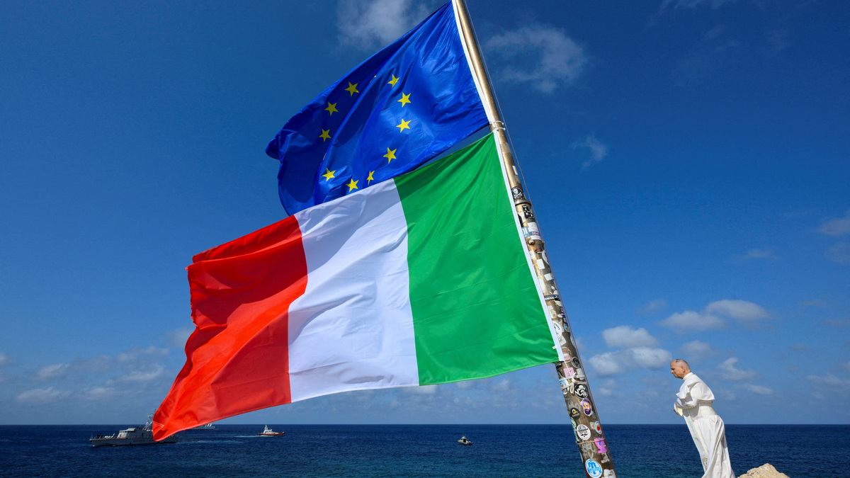 Pope Leo stands next to the European Union and Italy's flags  as he visits the island of Lampedusa, a key entry point for migrants crossing the Mediterranean Sea, during a pastoral trip, Italy, July 4, 2026.    Vatican Media/­Handout via REUTERS