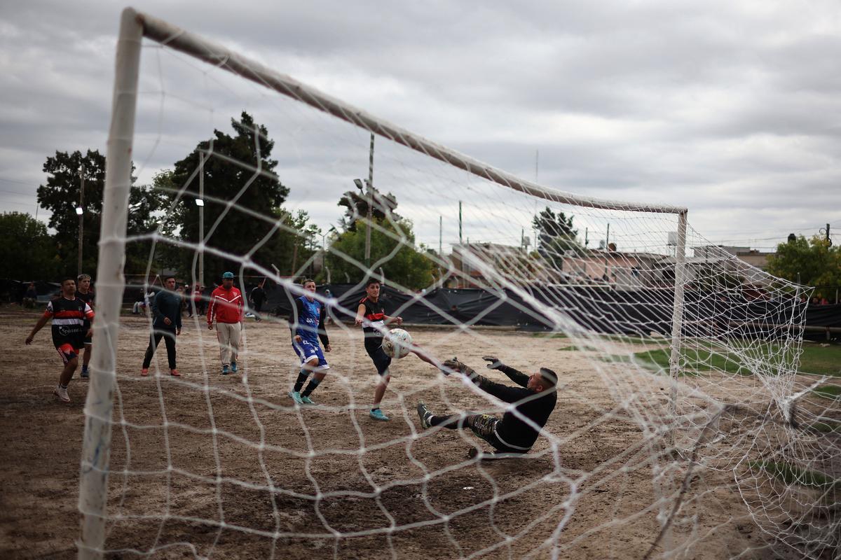 People play a soccer match during a one-day knockout tournament where teams pay an entry fee to compete for a cash prize of 2 million Argentine pesos (1,420 USD), in Ingeniero Budge, on the outskirts of Buenos Aires, Argentina, April 5, 2026. For three-time World Cup champions Argentina, football is a feverish passion that permeates every home and every makeshift dirt field, known as a "potrero," where youngsters play, dreaming of reaching the top leagues. REUTERS/Agustin Marcarian