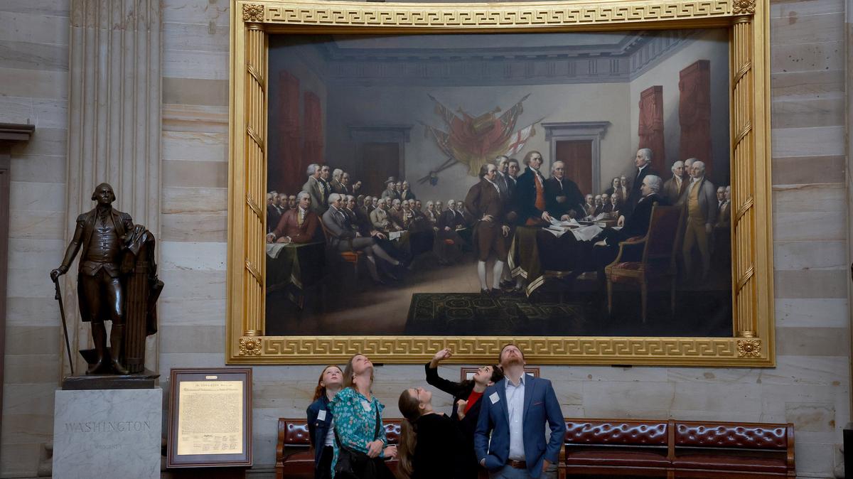 Visitors to the U.S. Capitol Rotunda take in the sights near the painting depicting the moment on June 28, 1776, when the first draft of the Declaration of Independence was presented to the Second Continental Congress on Oct. 17, 2023, in Washington, D.C.  (Joe Raedle/Getty Images/TNS)