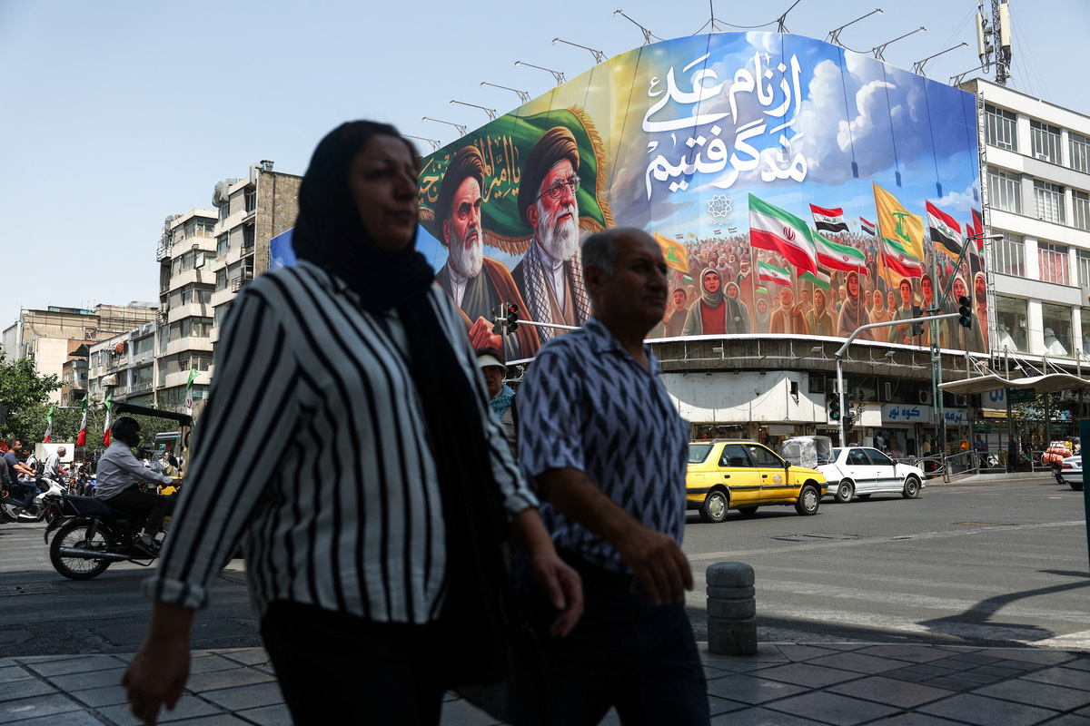 People walk past a billboard depicting the late leader of the Islamic Revolution, Ayatollah Ruhollah Khomeini, and the late Iran's Supreme Leader Ayatollah Ali Khamenei, on a street in Tehran, Iran June 6, 2026. Majid Asgaripour/WANA (West Asia News Agency) via REUTERS