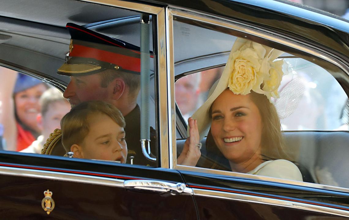 Smile and Wave Kate was in high spirits as she drove away from Harry and Meghan's nuptials with son Prince George on her lap. Photo by Gareth FULLER / POOL / AFP