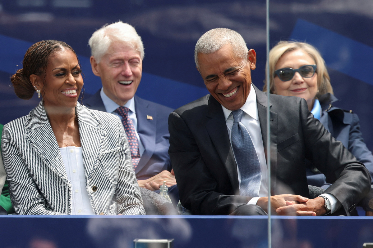 Former President Barack Obama and Michelle Obama laugh at the dedication ceremony for the opening of the Obama Presidential Center in Chicago on June 18, 2026. Seated behind them are former President Bill Clinton and Hillary Clinton.