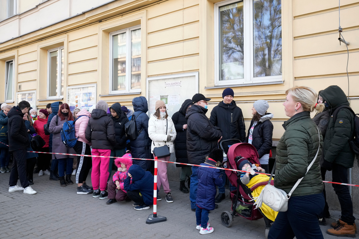 Ukrainians stand in line to apply for a national identity number in Warsaw, Poland, Wednesday. It was the first day Ukrainian refugees who fled the war at home were allowed to apply for a Polish ID number which will give them access to public services such as medical care and education.