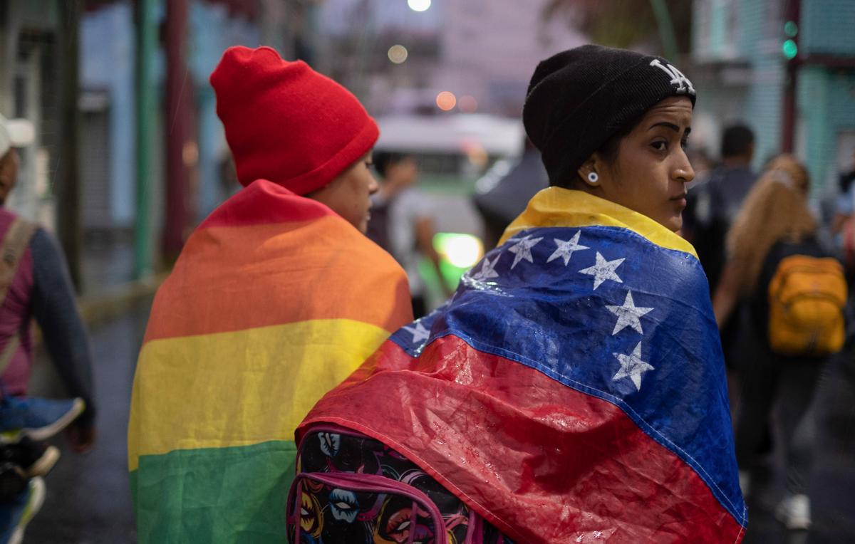 Una persona envuelta en una bandera venezolana con un grupo de migrantes en Chiapas, México, a principios del 6 de junio de 2022. El gobierno de EEUU extendió hasta marzo de 2024 un programa de protección temporal (TPS) que permite a algunos venezolanos y otros migrantes que no han regularizado su estatus migratorio permanecer legalmente en EEUU.
