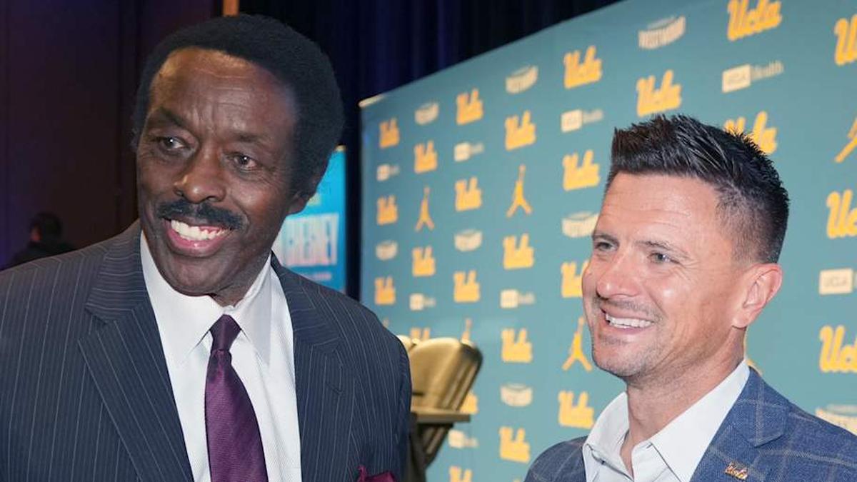  Dec 9, 2025; Los Angeles, CA, USA; UCLA Bruins football coach Bob Chesney (right) with CBS Los Angeles sports director Jim Hill at introductory press conference at Renee Luskin Conference Center Centennial Ballroom. Mandatory Credit: Kirby Lee-Imagn Images | Kirby Lee-Imagn Images 