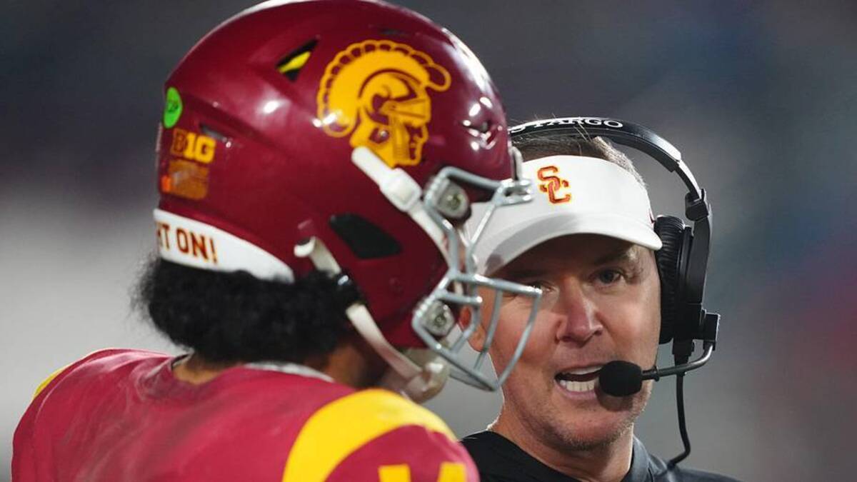  Nov 29, 2025; Los Angeles, California, USA; Southern California Trojans head coach Lincoln Riley (right) talks with quarterback Jayden Maiava (14) in the second half against the UCLA Bruins at United Airlines Field at Los Angeles Memorial Coliseum. Mandatory Credit: Kirby Lee-Imagn Images | Kirby Lee-Imagn Images 