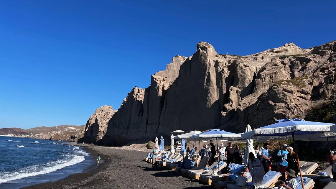  Royal Beach Club Santorini sits on a striking black-sand beach. 