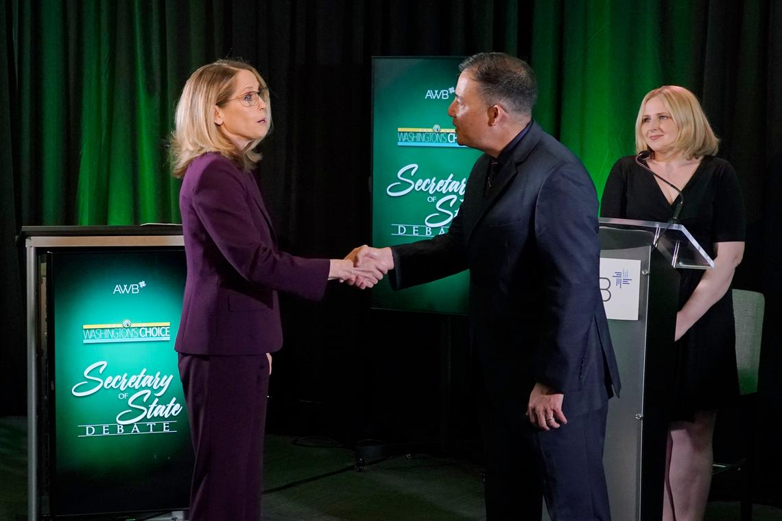 Washington Secretary of State Steve Hobbs, second from right, a Democrat, and Pierce County Auditor Julie Anderson, left, running as a nonpartisan, shake hands after taking part in a debate in Olympia.