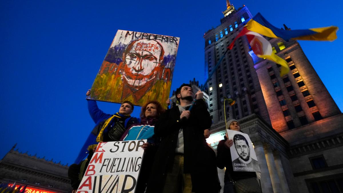 Activistas climáticos sostienen retratos del presidente ruso Vladimir Putin, a la izquierda, y del presidente ucraniano Volodymyr Zelenskyy durante una protesta que exige un embargo energético a Rusia y el fin de la guerra en Ucrania, en Varsovia, Polonia, el viernes 22 de abril de 2022.