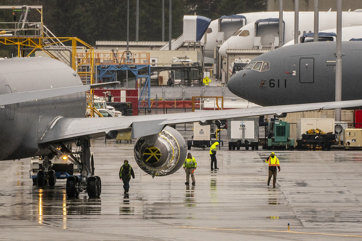 Workers stand near a Pratt & Whitney engine on a Boeing KC-46A Pegasus aerial refueling jet built for the U.S. Air Force at Boeing's airplane production facility in Everett, Washington.