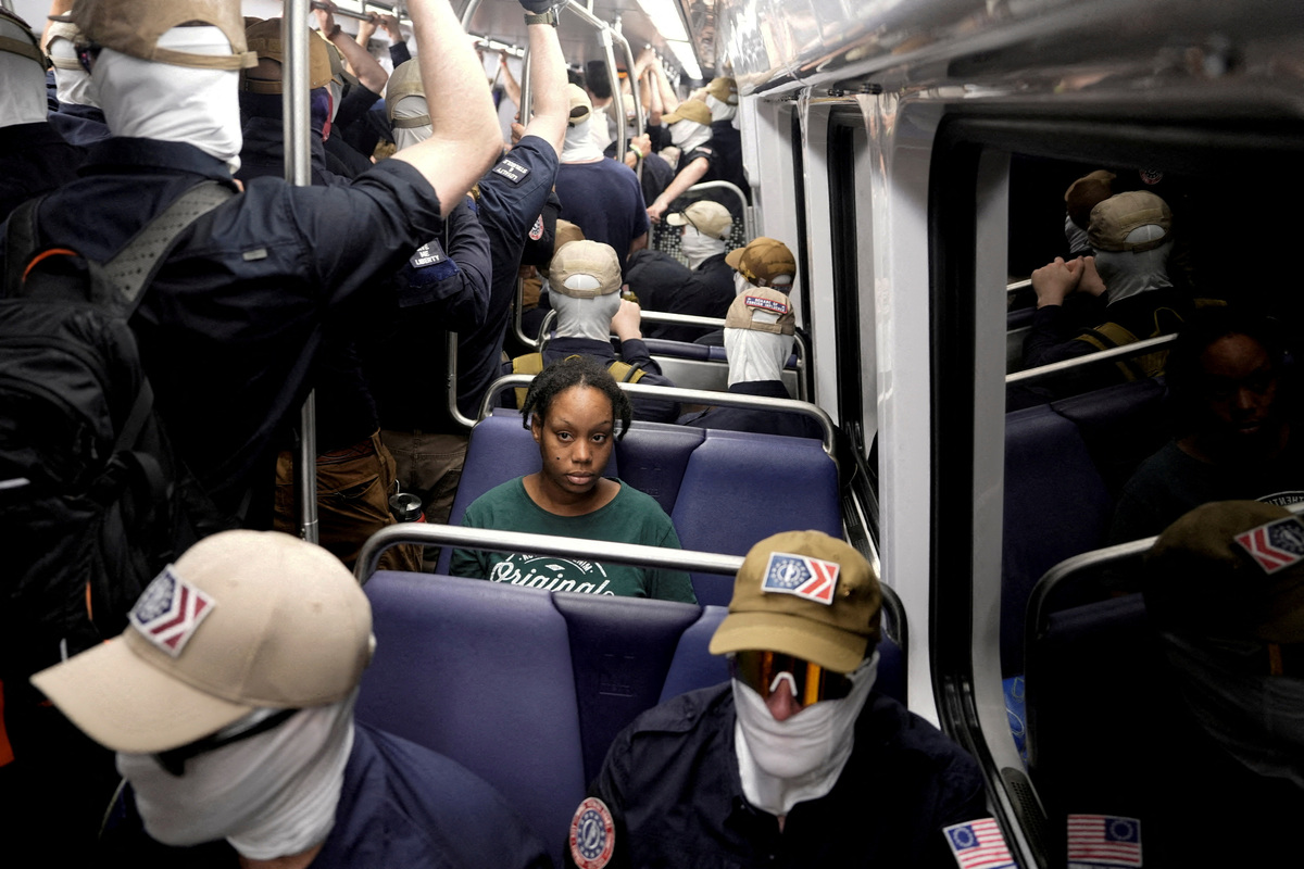 FILE PHOTO: A commuter sits as members of the group Patriot Front ride the metro on the 250th anniversary of U.S. independence on the Fourth of July in Washington, D.C., U.S., July 4, 2026. REUTERS/Cheney Orr/File Photo