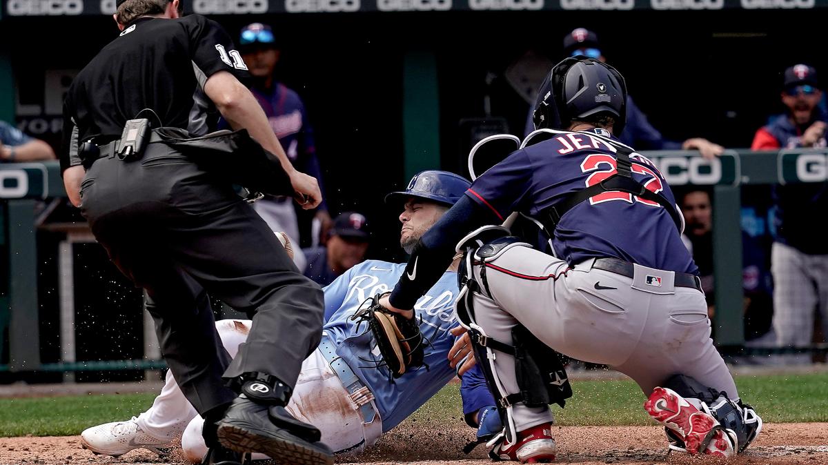 Kansas City Royals’ Andrew Benintendi is tagged out at home by Minnesota Twins catcher Ryan Jeffers as he tried to score on a fly out hit by Salvador Perez during the fourth inning of a baseball game against Thursday, April 21, 2022, in Kansas City, Mo. (AP Photo/Charlie Riedel)