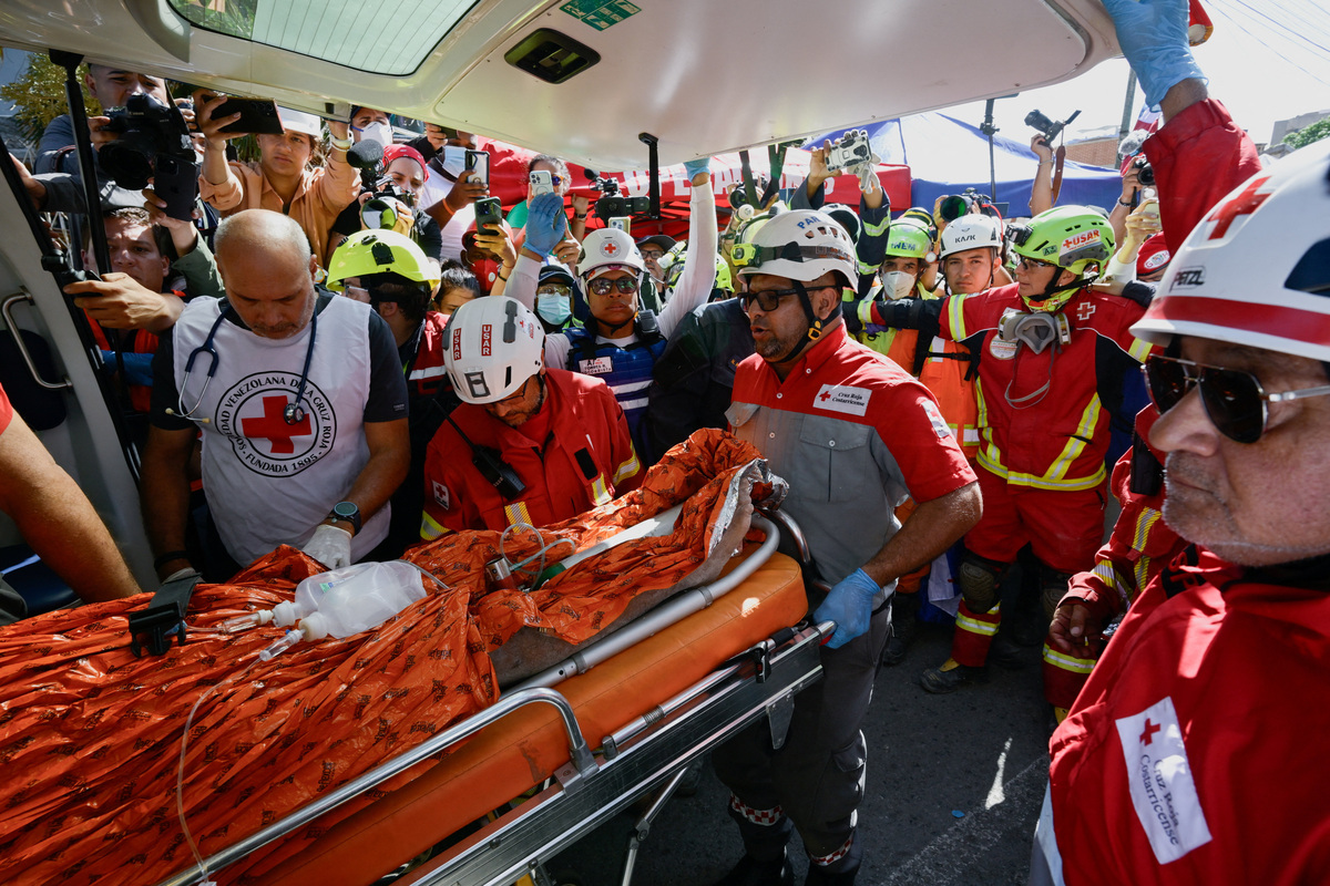 Rescue workers transport survivor Hernan Alberto Gil, who was trapped for over a week at a collapsed mall following June 24 earthquakes, in La Guaira, Venezuela, July 2, 2026. REUTERS/Maxwell Briceno