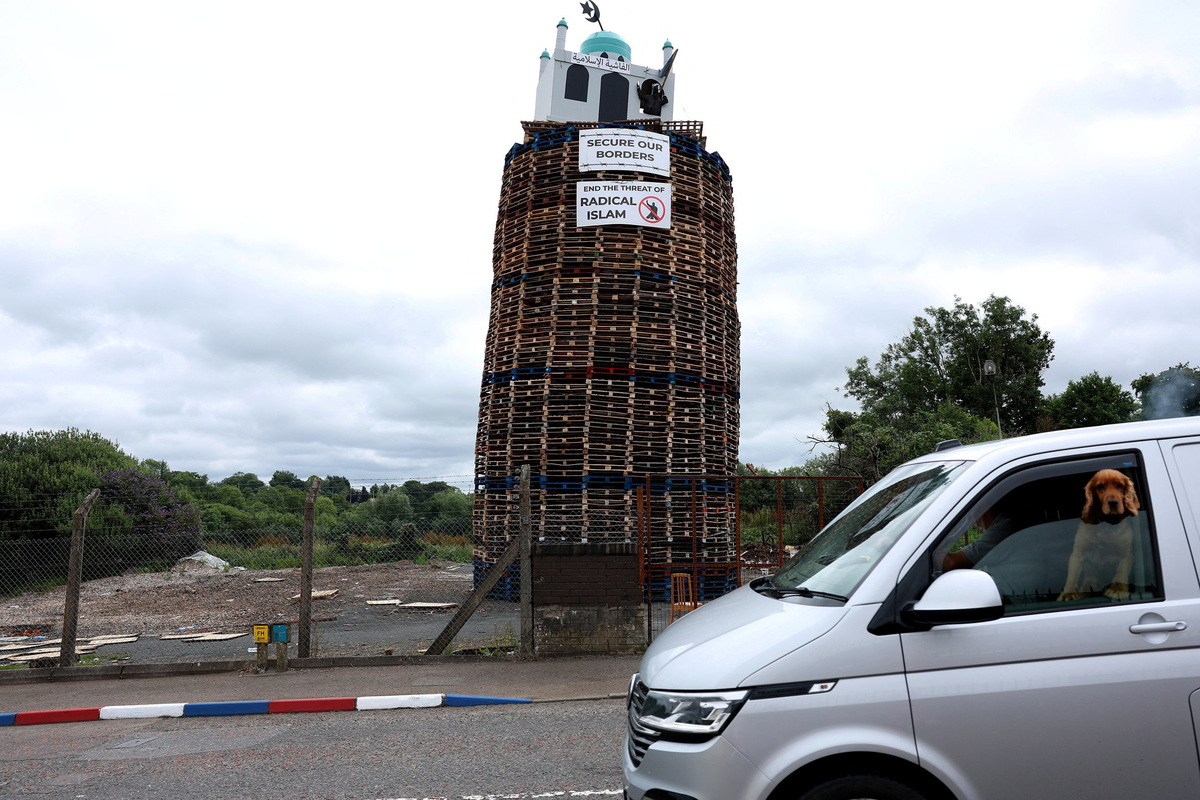 An effigy of a person holding a knife in a mosque stands atop the Moygashel bonfire ahead of its lighting as part of the annual bonfire events marking the 1690 Battle of the Boyne, in Moygashel, Northern Ireland, July 9, 2026. REUTERS/Cathal McNaughton