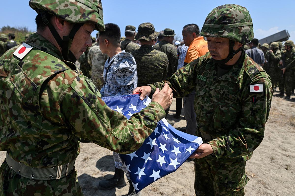 Japan Ground Self-Defense Force (JGSDF) soldiers fold a U.S. flag during the Joint Task Force (JTF) Maritime Strike, part of Balikatan, the annual joint military exercises between the United States and the Philippines, at Culili Point Sand Dunes, Paoay, Ilocos Norte province, Philippines, May 6, 2026. REUTERS/Noel Celis