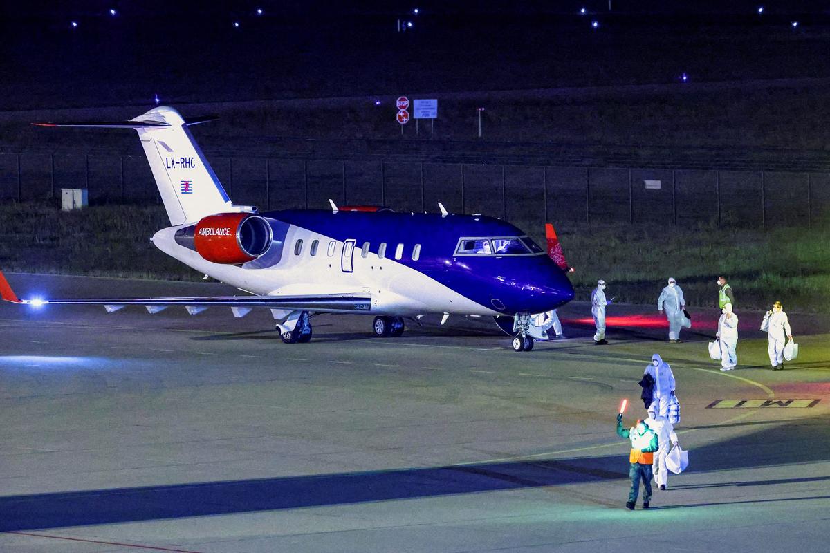 Personnel in hazmat suits walk near a plane carrying passengers evacuated from the cruise ship MV Hondius, which was affected by a hantavirus outbreak, after it landed at the Eindhoven Air Base in Eindhoven, Netherlands May 12, 2026. REUTERS/Piroschka van de Wouw