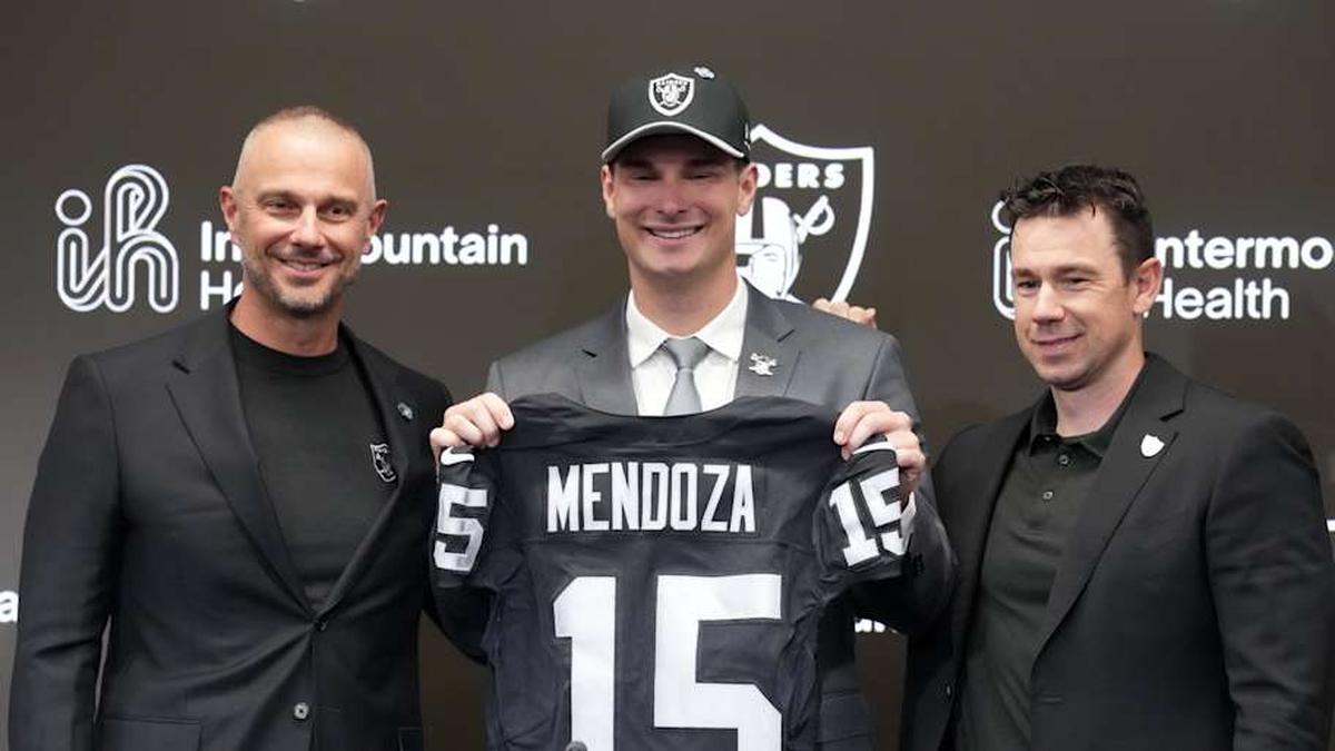  Apr 24, 2026; Henderson, NV, USA; Las Vegas Raiders quarterback Fernando Mendoza (center) poses with jersey at introductory press conference at Intermountain Health Performance Center flanked by general manager John Spytek (left) and head coach Klint Kubiak after being selected as the No. 1 pick in the 2026 NFL Draft. Mandatory Credit: Kirby Lee-Imagn Images | Kirby Lee-Imagn Images 