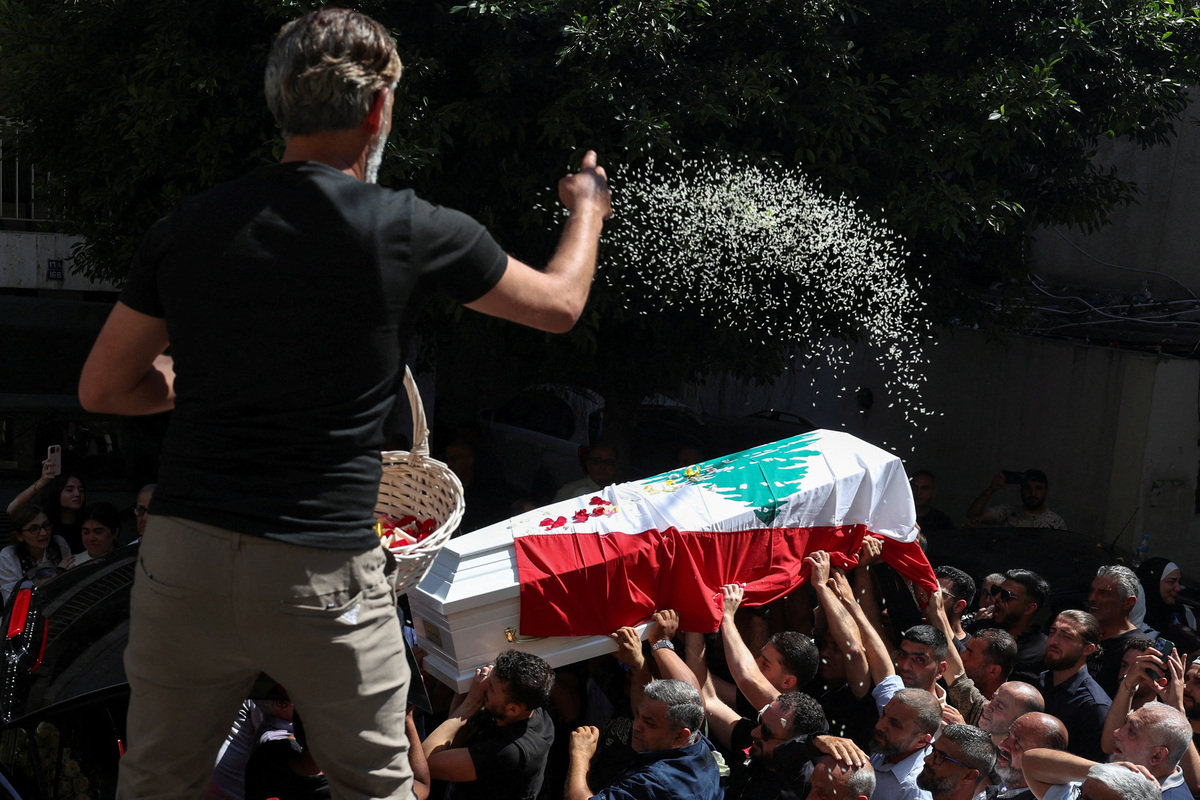 A man throws flower petals as pallbearers carry a coffin during the funeral of Brigadier General Wissam Sabra, who was killed in an Israeli strike targeting their military vehicle on the Khardali-Nabatieh road in south Lebanon on Saturday, in Beirut, Lebanon June 7, 2026. REUTERS/Mohamed Azakir