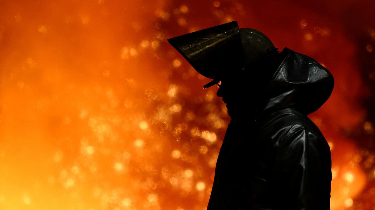 FILE PHOTO: A steel worker stands amid sparks of raw iron coming from a blast furnace at a ThyssenKrupp steel factory in Duisburg, Germany, November 5, 2025. REUTERS/Leon Kuegeler/File Photo