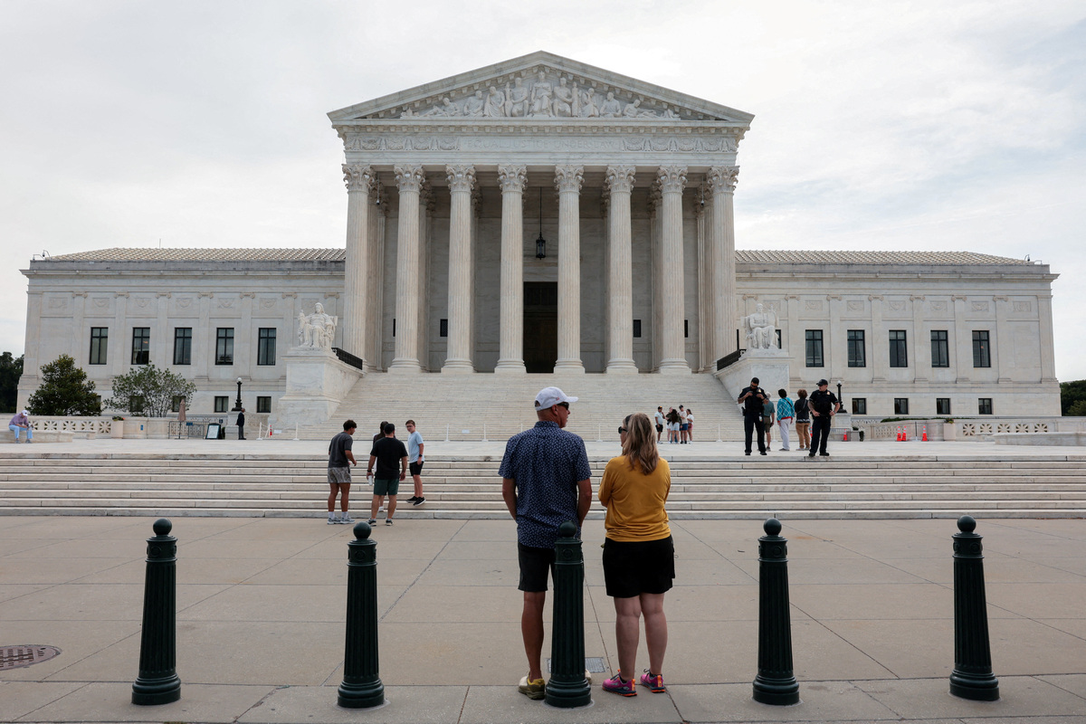 FILE PHOTO: People stand outside the U.S. Supreme Court in Washington, D.C., U.S., June 22, 2026. REUTERS/Kylie Cooper/File Photo