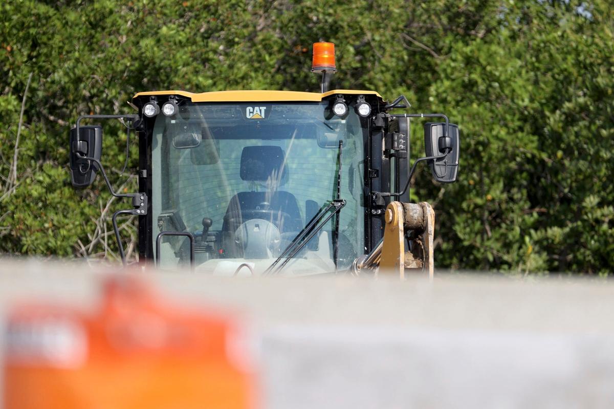 Un cargador frontal permanece en el lugar donde un investigador forense de la Policía del Condado Pinellas investiga la escena en los carriles hacia el oeste de la I-275 cerca de Gandy Boulevard, el viernes 23 de septiembre de 2022, en St. Petersburg, Florida. Michael Hartwick, un agente policial de la Florida que trabajaba en un turno nocturno para proporcionar seguridad en una zona de construcción murió tras ser golpeado por un trabajador que operaba una cargadora frontal, dijeron las autoridades.