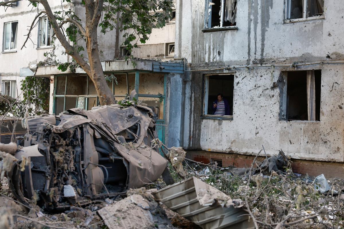 A woman inspects a building damaged during Russian missile and drone strikes, amid Russia's attack on Ukraine, in Kyiv, Ukraine June 2, 2026. REUTERS/Valentyn Ogirenko