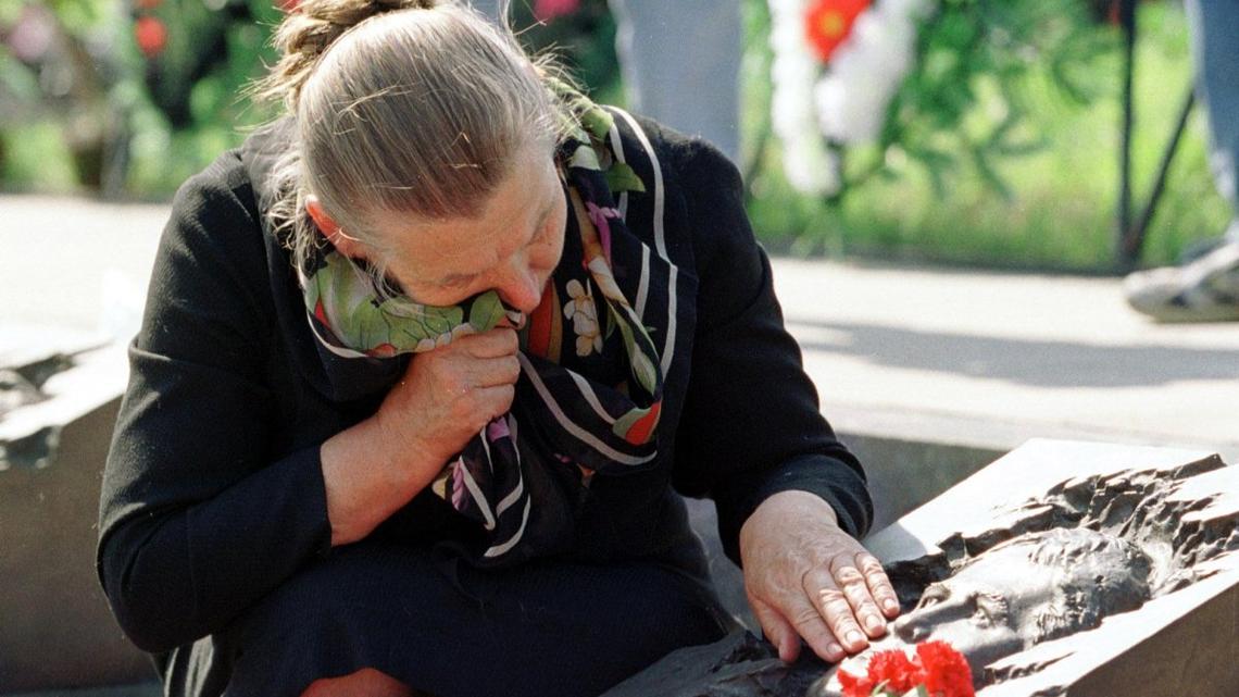 Valentina Lopatyuk cries near the bas-relief portrait of her son Viktor on his grave at a cemetery in Moscow on April 26, 2000, on the anniversary of the 1986 Chernobyl disaster. File Photo by Maxim Marmur/UPI