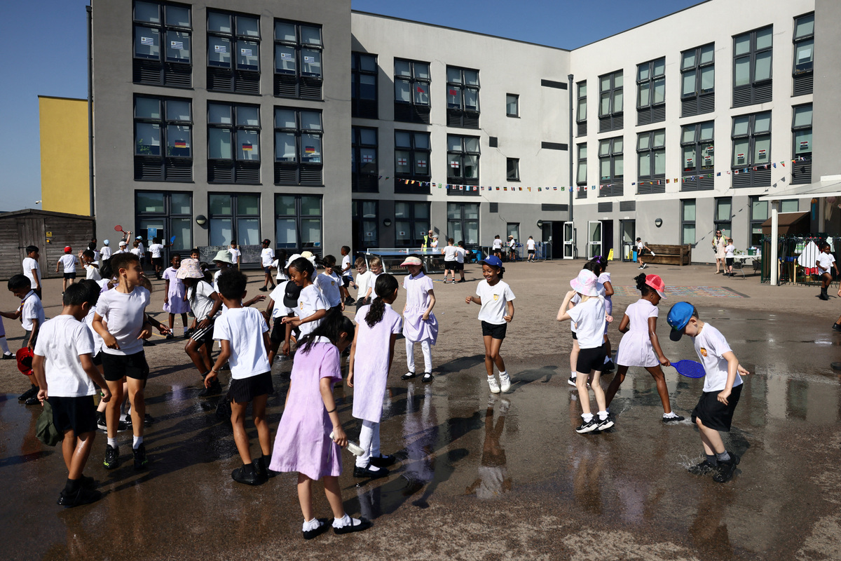 Pupils play outside after water play at the Harris Academy Primary Mayflower school, as Britain experiences record temperatures disrupting schools and transport networks, in Grays, Britain, June 24, 2026. REUTERS/Jack Taylor